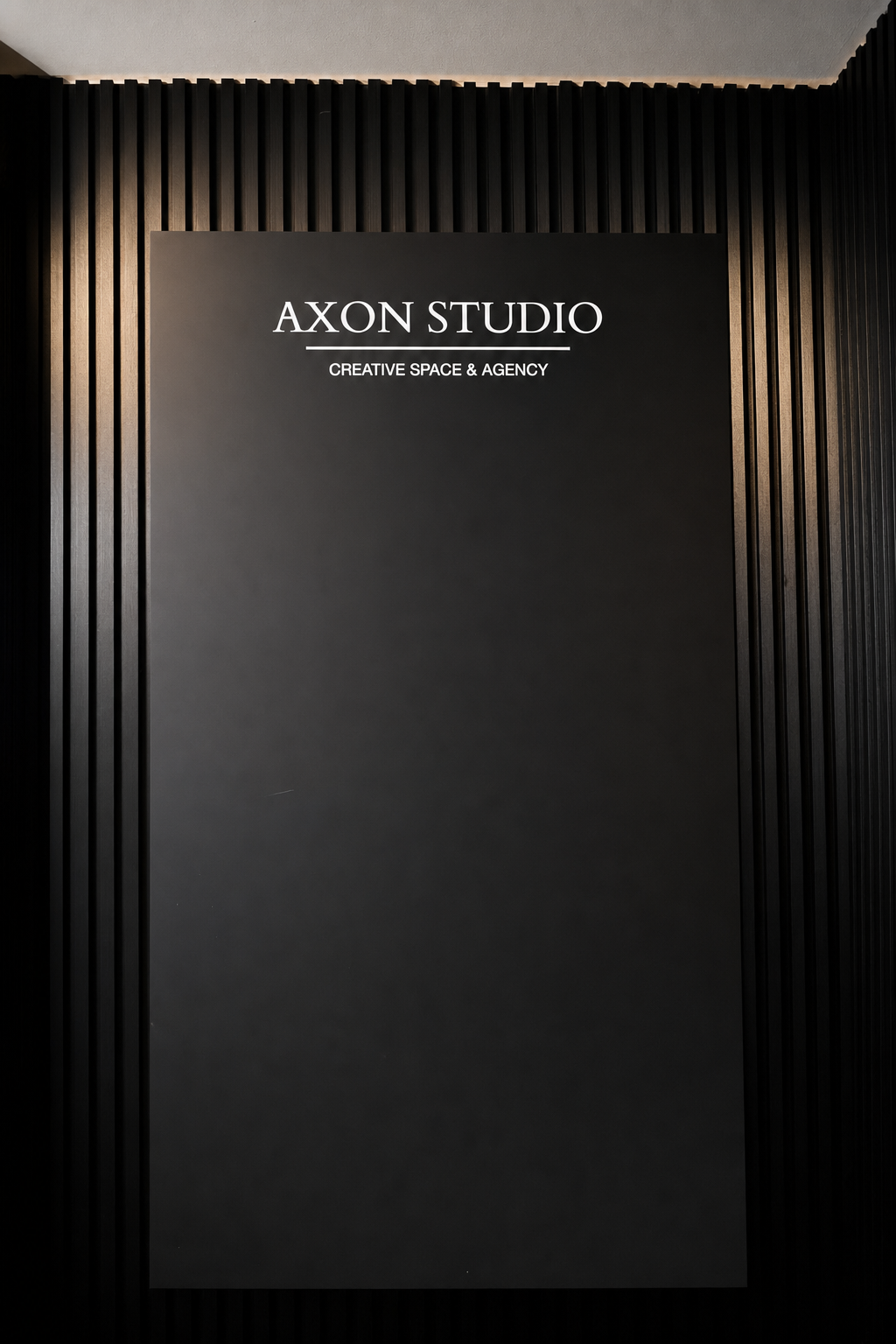 Black slat wall with the AXON STUDIO sign