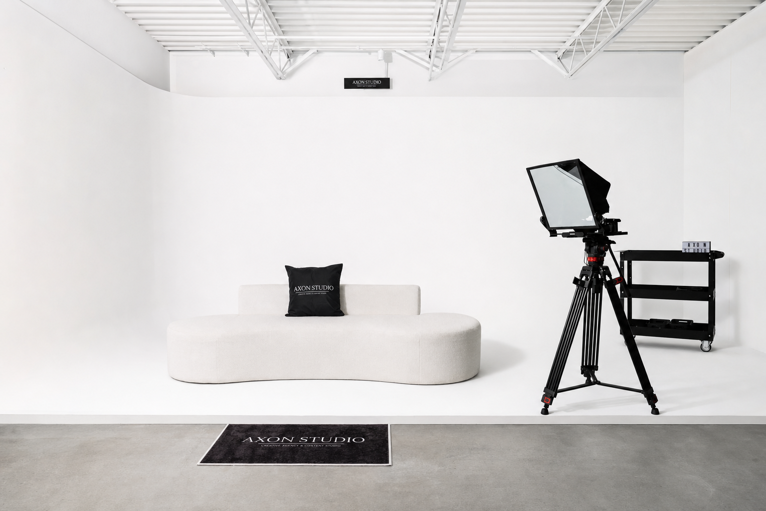 White cyclorama studio with a curved sofa and teleprompter