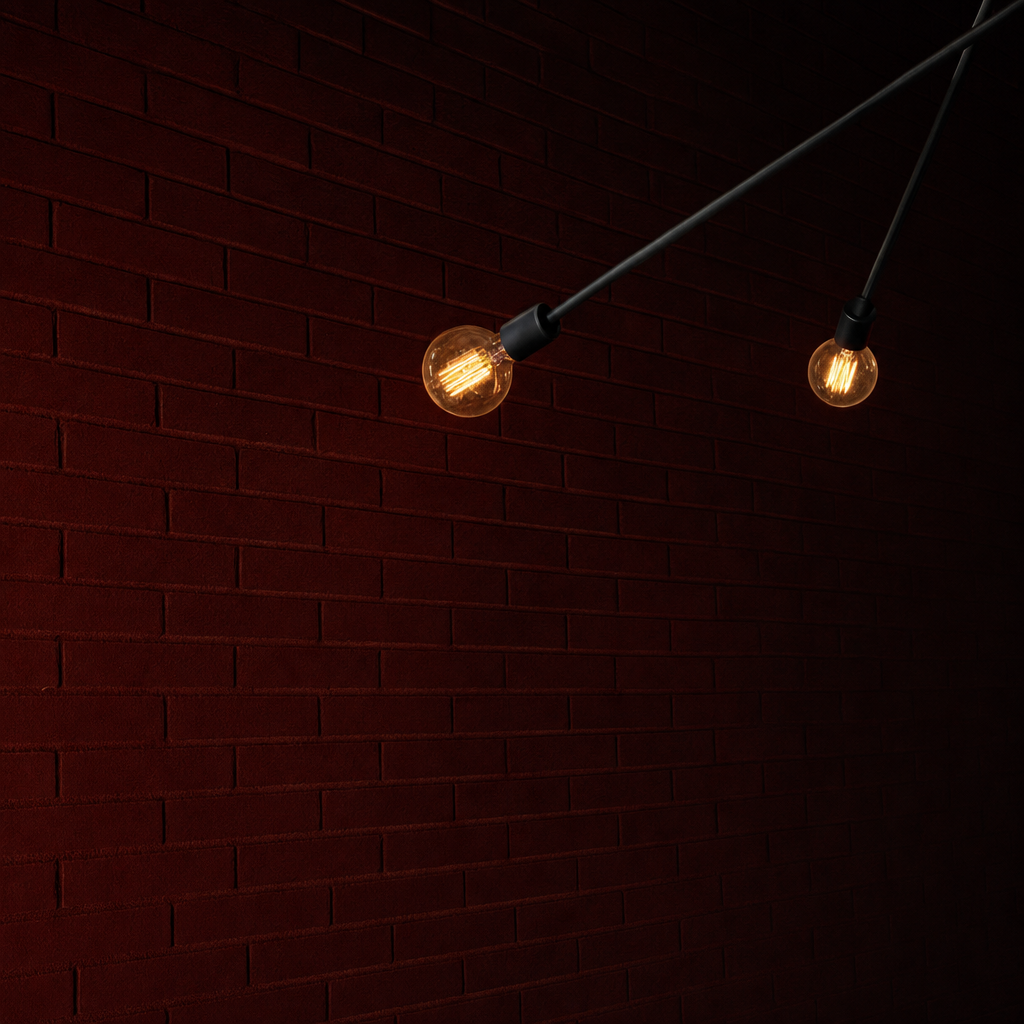 Edison bulbs glowing against dark red painted brick